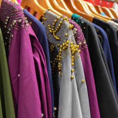 Traditional arabic dresses (abaya) in a row in a store at Abu Dhabi Grand Mosque