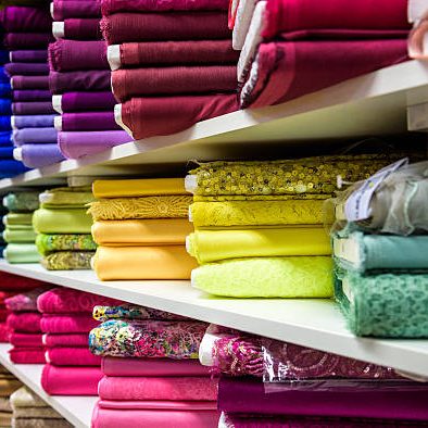 Rolls of fabric and textiles in a factory shop or  store or bazar. Multi different colors and patterns on the market. Industrial fabrics.
